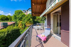 a porch with a bench and a table on a balcony at Casetta di Rosetta in Arizzano +30 photos
