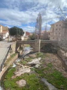 a stone bridge over a river in a city at Exclusive apartment with a terrace in Mora de Rubielos +4 photos