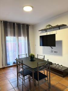 a dining room with a table and chairs and a tv at Exclusive apartment with a terrace in Mora de Rubielos
