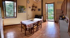 a kitchen with a table with chairs and a refrigerator at Casa San Rocco in Guardavalle