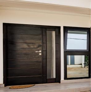a black door in a room with a window at Chambre Blanche in Douala