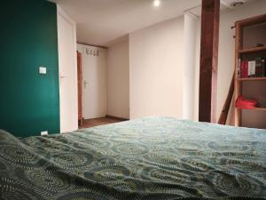una camera da letto con un letto e una parete verde di Chambre à louer a Pontivy
