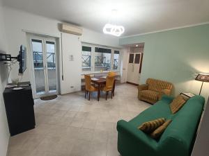 salon z zieloną kanapą i stołem w obiekcie City Break Nomentana w Rzymie