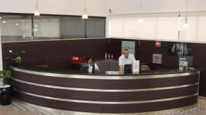 a man and a woman sitting at a reception counter at Valentim Palace Hotel in Valentim Gentil +41 photos