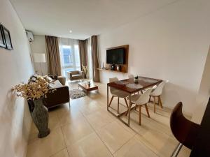 a living room with a table and chairs and a television at Estadía de Lujo con vista soñada a la Bahía grande de Nordelta in Benavídez