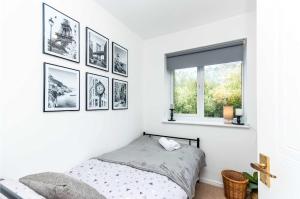 a bedroom with black and white pictures on the wall at Modern 3 Bedroom Home in Swindon with Parking in Swindon