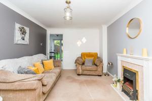 a living room with a couch and a fireplace at Modern 3 Bedroom Home in Swindon with Parking in Swindon +7 photos