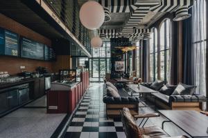 ナイヤンビーチにあるSugar Marina Hotel -AVIATOR- Phuket Airportのソファ、テーブル、窓のあるレストラン