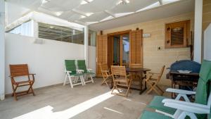 patio z krzesłami, stołem i oknem w obiekcie Villa Sapore di mare w mieście Favignana