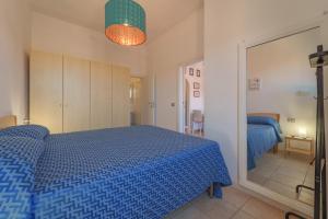 ein Schlafzimmer mit einem blauen Bett und einem Spiegel in der Unterkunft Nel cuore di Rio Marina in Rio Marina