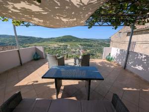 a table and chairs on a patio with a view at Studio apartman Belvedere in Motovun