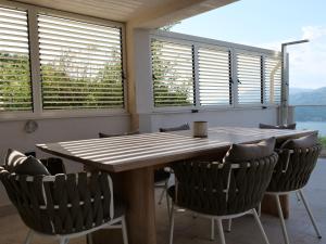 une salle à manger avec une table et des chaises en bois dans l'établissement Boka View House, à Luštica 51 autres photos