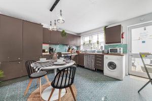a kitchen with a table and chairs and a washing machine at Relax 2BDR with Sauna, Hot Tub and Cinema in London
