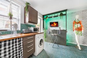 a kitchen with a washer and dryer and a fireplace at Relax 2BDR with Sauna, Hot Tub and Cinema in London +8 photos