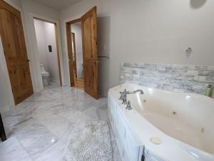 a white bathroom with a tub and a toilet at Springs Wish in Eureka Springs +15 photos