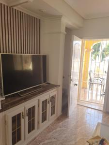 Una sala de estar con un televisor de pantalla plana grande. en Casa la Fana, en Orihuela Costa