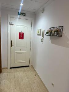 a hallway with a white door with a sign on it at Costa Marina III - Vistas inmejorables in El Borseral