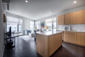 una cucina con mobili in legno e un soggiorno di Luxury Private Apt with Pool a White Plains