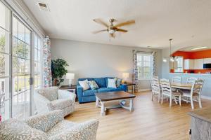 a living room with a blue couch and a table at Palmy Days @ Ironwood 424 in Myrtle Beach