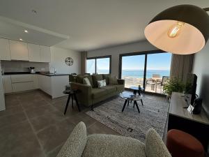 a living room with a couch and a kitchen at Sunset Horizon - BY SCH in Pederneira