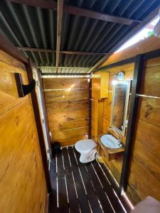 Un baño de madera con inodoro y lavabo. en Plancton House Atins, en Atins 12 fotos más