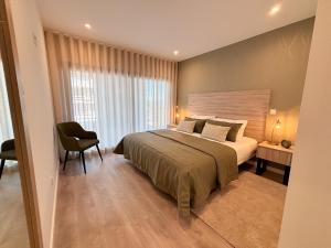 a bedroom with a large bed and a chair at Sunset Horizon - BY SCH in Pederneira +32 photos