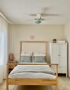 a bedroom with a bed with a ceiling fan at The Roof in Kfar Blum