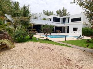a villa with a swimming pool and a house at Keur buur malick in Ngaparou