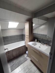 a bathroom with a tub and a sink and a bath tub at Chez Mona in Florenville