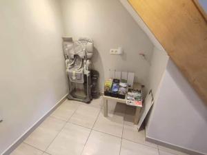 a small room with a refrigerator and a small shelf at Chez Mona in Florenville