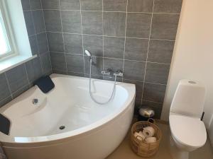 eine weiße Badewanne im Bad mit WC in der Unterkunft Private home with sea view in Ilulissat + 15 Fotos