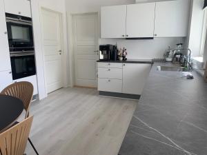 eine Küche mit weißen Schränken und einem Tisch und Stühlen in der Unterkunft Private home with sea view in Ilulissat