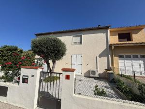 a white house with a fence and a tree at Maison climatisée 5 pièces avec jardin privé et parking, proche gare et centre à Argelès-sur-Mer - FR-1-388-217 in Argelès-sur-Mer