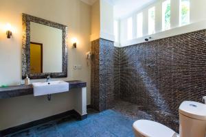 a bathroom with a sink and a mirror at Ecosfera Hotel & Spa in Canggu
