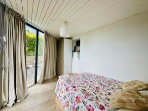 ein Schlafzimmer mit einem Bett und einem großen Fenster in der Unterkunft Home Mirador Castellvell in Castellvell