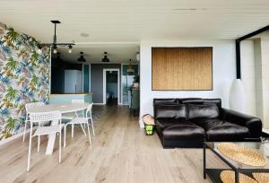 ein Wohnzimmer mit einer schwarzen Ledercouch und einem Tisch in der Unterkunft Home Mirador Castellvell in Castellvell + 13 Fotos