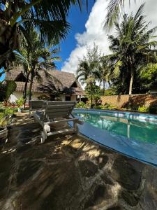 eine Holzbank neben einem Pool in der Unterkunft Villa Tata Diani in Diani Beach