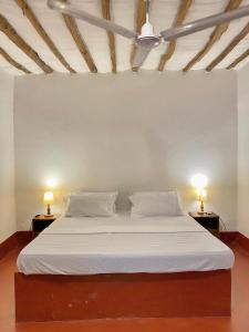 ein Schlafzimmer mit einem weißen Bett mit zwei Lampen an Tischen in der Unterkunft Villa Tata Diani in Diani Beach + 13 Fotos