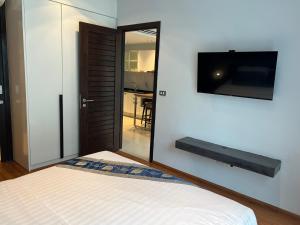 a bedroom with a bed and a tv on the wall at EMERALD TERRACE CONDO 52-FAMILY 1 Bedroom POOL VIEW in Patong Beach