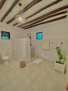 ein Badezimmer mit einem WC und einer Topfpflanze in der Unterkunft Villa Tata Diani in Diani Beach
