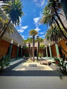 a courtyard with palm trees and a building at camping les dunes 5 étoiles mobil home 6 personnes A16 in Torreilles