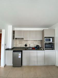 Una cocina con gabinetes blancos y un fregadero. en Loft céntrico y moderno con vista al lago, en San Carlos de Bariloche