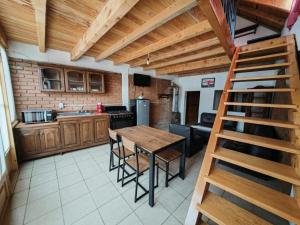 a kitchen with a wooden table and chairs and a staircase at Cabañas los Cedros in Santiago Oxtempan