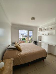 Un dormitorio con una cama grande y una ventana en Loft céntrico y moderno con vista al lago, en San Carlos de Bariloche