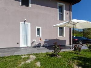 a patio with an umbrella and a table and a car at Dimora Molino Galeotto , Giardino e vista Appennino in Pavullo nel Frignano