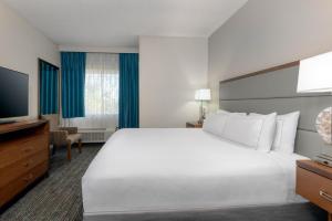 a hotel room with a large bed and a flat screen tv at DoubleTree by Hilton Hotel West Palm Beach Airport in West Palm Beach
