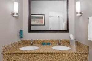 a bathroom with two sinks and a mirror at DoubleTree by Hilton Hotel West Palm Beach Airport in West Palm Beach