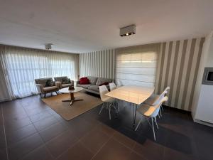 a living room with a couch and a table and chairs at Vakantiehuis De Panne in De Panne +7 photos