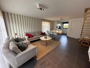 a living room with two couches and a table at Vakantiehuis De Panne in De Panne