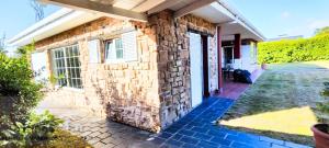 a brick house with a stone wall at Guirigay CASA CON PISCINA in Muros de Nalón
